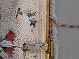 a person holding a beaded purse with a chain around it