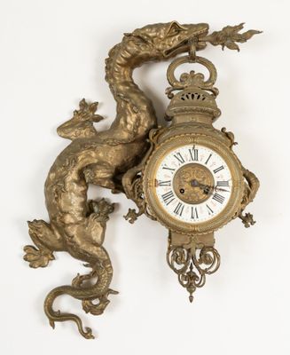 a gold clock with a dragon on it on the wall