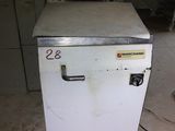 a small white freezer sitting on the floor in a room