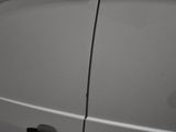 a white van that has been painted white and has a hole in the side of the van