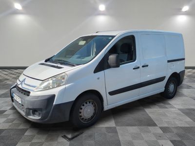 la camionnette blanche est garée sur un sol carrelé en damier