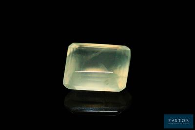 une pierre de quartz verte posée sur une surface noire