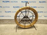 an image of a wheel that is sitting on a stand in front of a wall