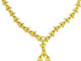 an image of a gold necklace with green stones on a white background