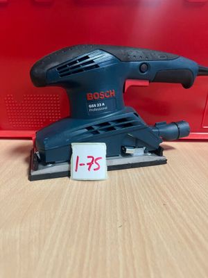 une ponceuse orbitale Bosch posée sur une table, avec son étiquette de prix