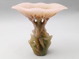 a small vase with a flower on it on a white surface
