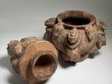 pair of ancient clay vases on a white surface with a gray background