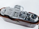 a silver camera with a brown strap on it