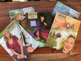 des livres posés sur une table en bois, avec des photos d'une femme et d'un homme