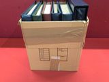 une boîte en carton remplie de livres posée sur une table rouge
