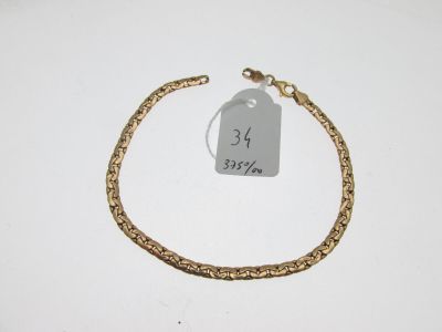 Gros plan sur un bracelet en or portant une étiquette