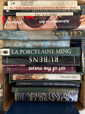 plusieurs livres empilés dans une boîte