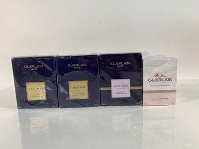 three boxes of perfume sitting on top of a white table
