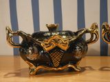 two black and gold teapots sitting on a wooden table