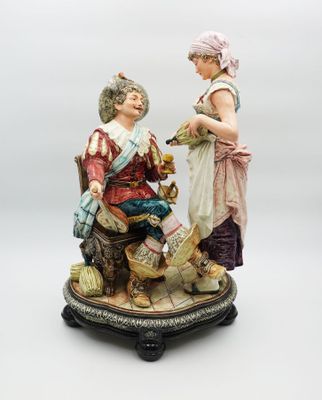 figurine représentant un homme et une femme assis sur un banc
