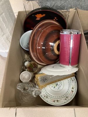 une boîte en carton remplie d'objets hétéroclites sur le sol