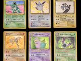 Les cartes Pokémon sont présentées sur une surface noire avec un fond noir.