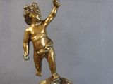 a gold figurine of a boy on top of a box