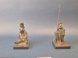 two figurines of a man and a woman sitting on a bench