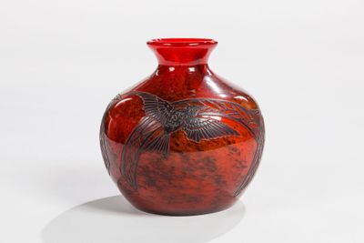 a red vase with a bird on it on a white surface
