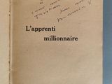 un livre ouvert, sur lequel figurent des inscriptions, posé sur une surface bleue