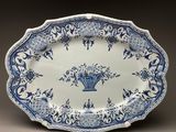 blue and white platter with a basket of flowers on it