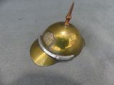a small brass helmet with a metal spike sticking out of it