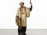an image of a statue of a priest holding a cross