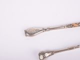 two spoons and a ladle on a white surface