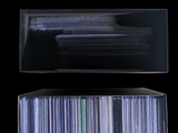 a lot of cds in a clear box on a black background