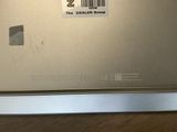 a silver laptop with a barcode on the screen
