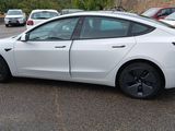 a white tesla model s parked in a parking lot