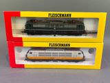 two boxed boxes with a model train in them on a gray surface