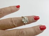 a woman ' s hand with a red manicure holding a diamond ring