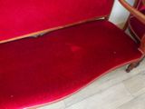a red couch that is sitting on a wooden floor