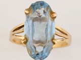 Gros plan sur une bague en or ornée d'une topaze bleue