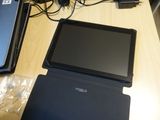 a laptop and a tablet on a table with other electronics