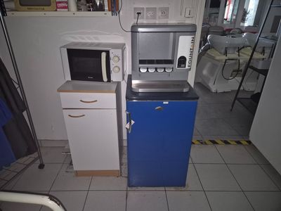 two microwaves sitting next to each other in a kitchen