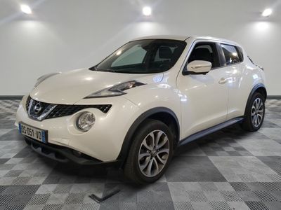 the white nissan juke suv is parked on a checkered floor