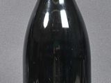 bottles of wine are lined up on a table with a gray background