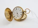 a gold pocket watch with a chain on a white surface