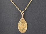 un collier avec une pièce d'or et une chaîne en or sur un mannequin, mannequin, mannequin, mannequin, mannequin, mannequin, mannequin, mannequin, mannequin, mannequin