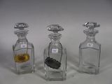three small glass bottles with gold and silver items in them