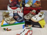 a pile of children ' s shoes and shoes on a bed