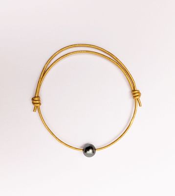 BRACELET en cuir doré orné d'une perle de Tahiti, avec nœud …