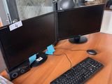un bureau sur lequel sont posés deux écrans d'ordinateur et un clavier