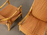 pair of bamboo lounge chairs with plaid upholstered cushions