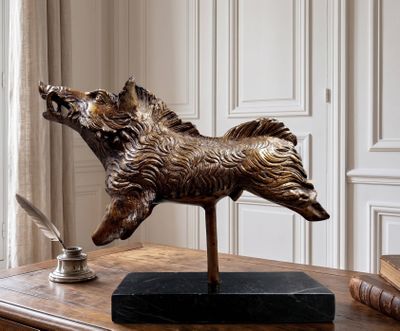 a statue of a dog on a table with a pen and inkwell