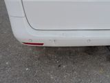 rear end of a white car with a small dent in the bumper