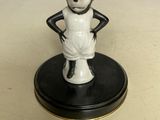 une figurine représentant une souris noire et blanche posée sur un socle noir